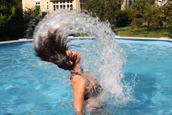 Frau im Cranpool Royal Schwimmbecken, während sie mit nassen Haaren aus dem Wasser auftaucht